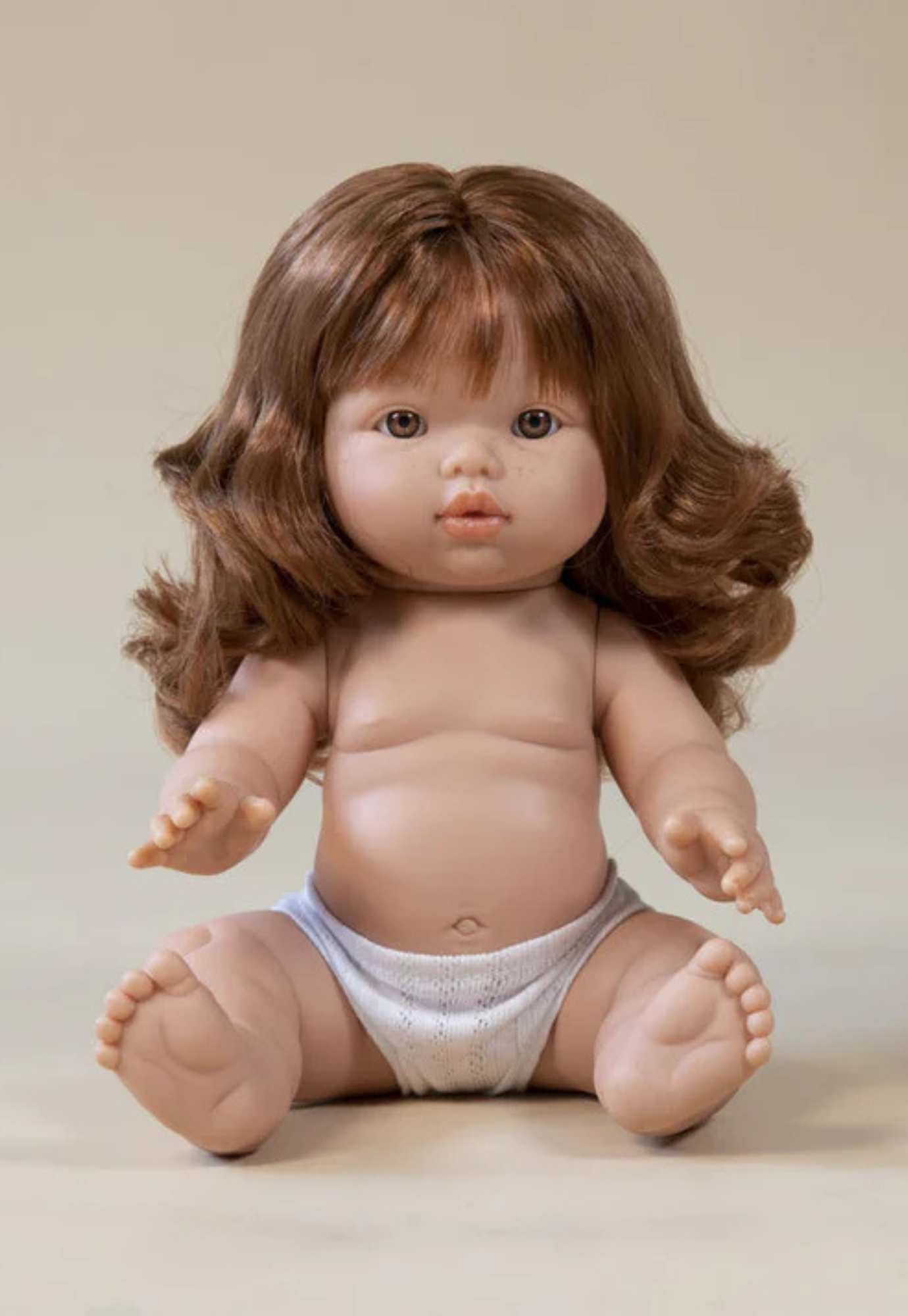 close up of mini coletos sophia doll showing lifelike red wavy hair and brown eyes on phthalate-free vinyl