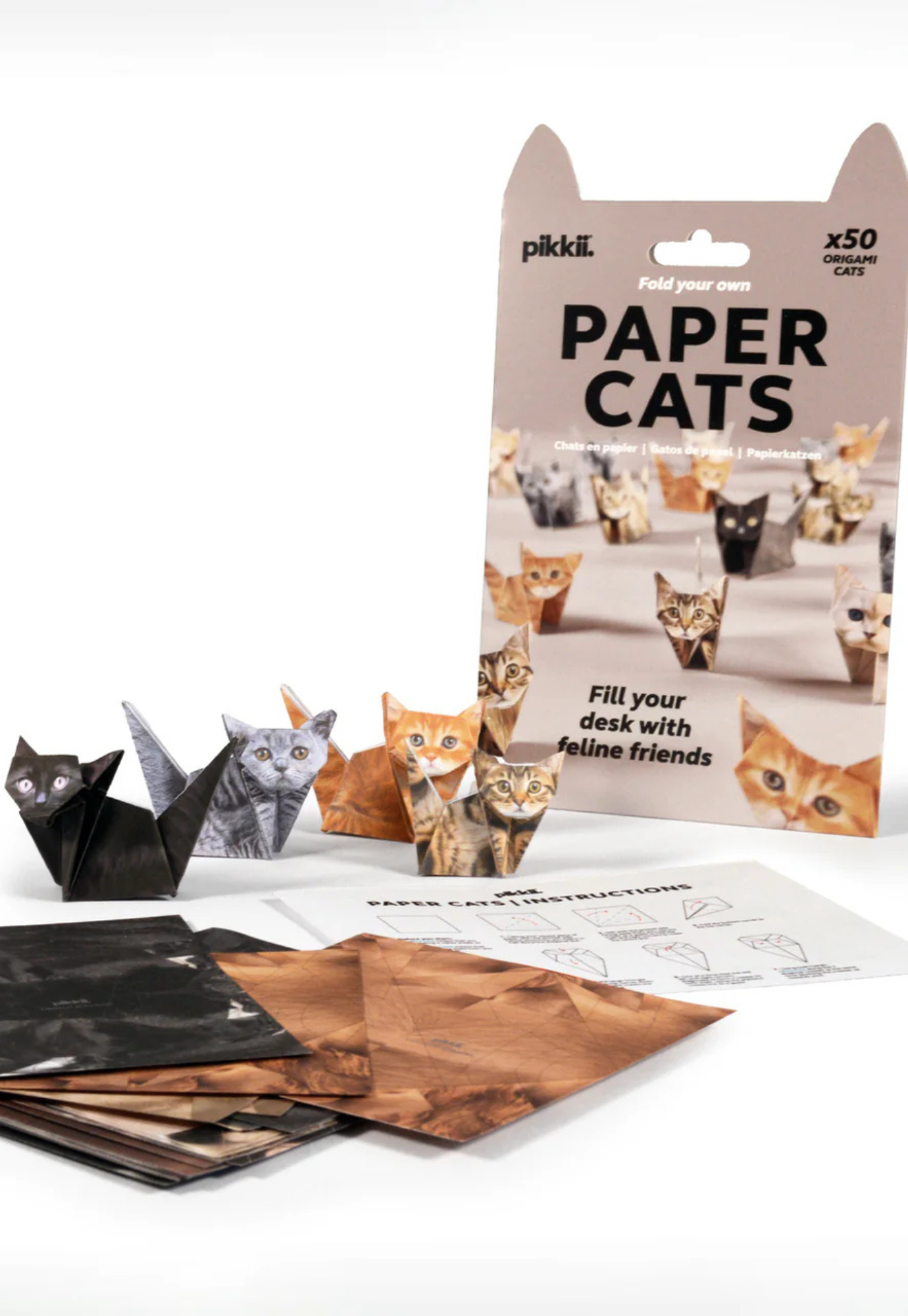 paper cats origami cat craft kit on desk with four folded cat figure and workspace accessories