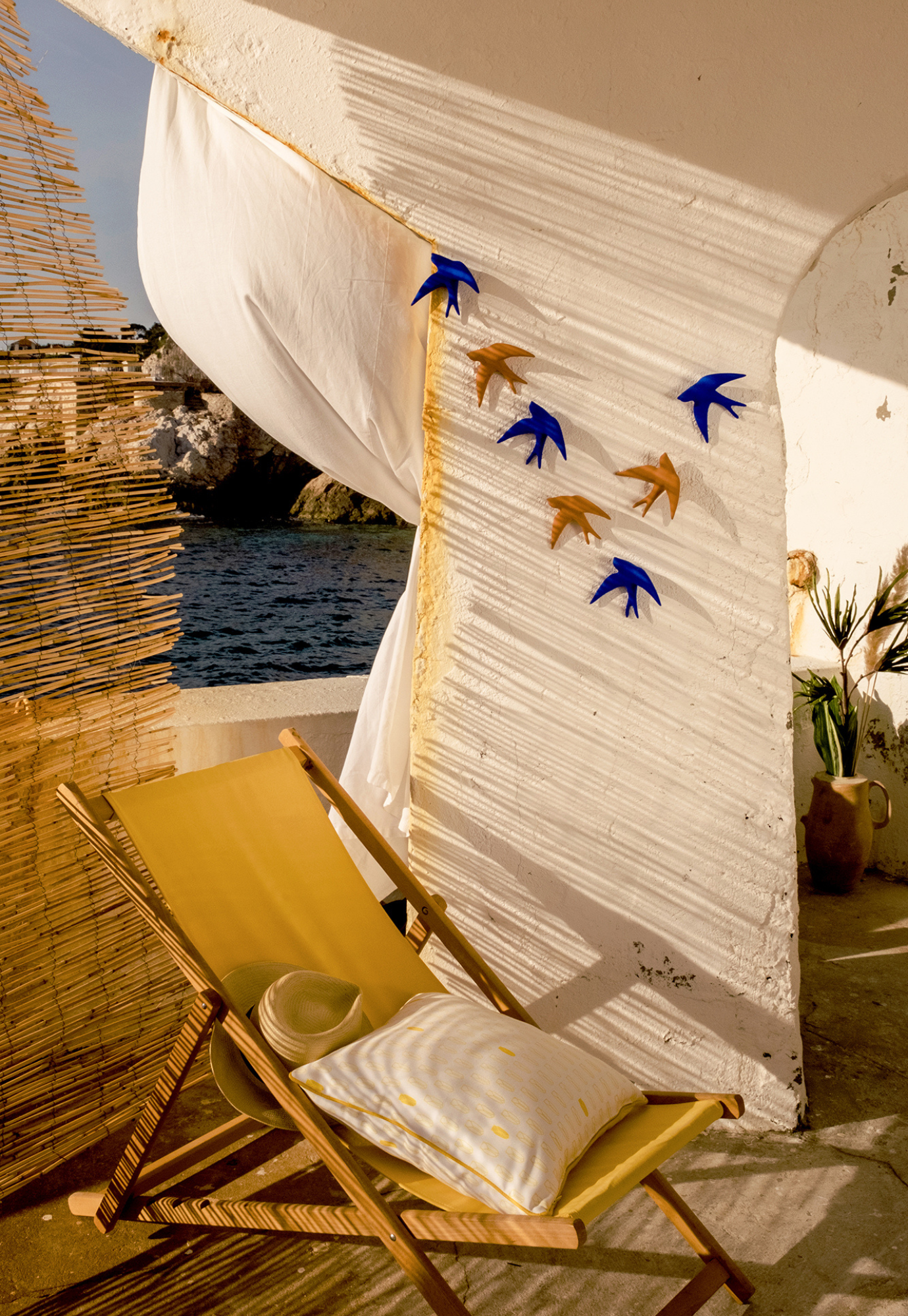 swallow wall décor terracotta hanging on wall in on outdoor living room setting with neutral tones